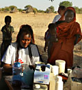 MSF nurse and midwife Lilian Anyango from Kenya (5th from right, seated) and MSF Santino Mayiik from Southern Sudan (2nd from right,white shirt) dispenses medication to patients who have attended the MSF mobile clinic in Abien Dau transit returnee camp, Warrup State, Southern Sudan. 11 January, 2011. Photo: © Kate Geraghty/ Fairfax Media